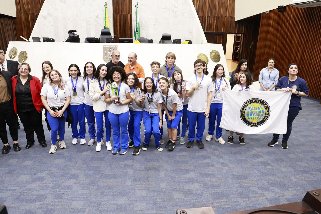 Alunos do Colégio Estadual do Paraná comemoram com troféu e medalhas a conquista do Debatedores Nota Mil 2026, no Plenário da Assembleia Legislativa.